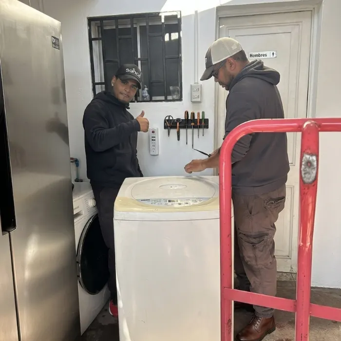 Técnicos reacondicionando una lavadora